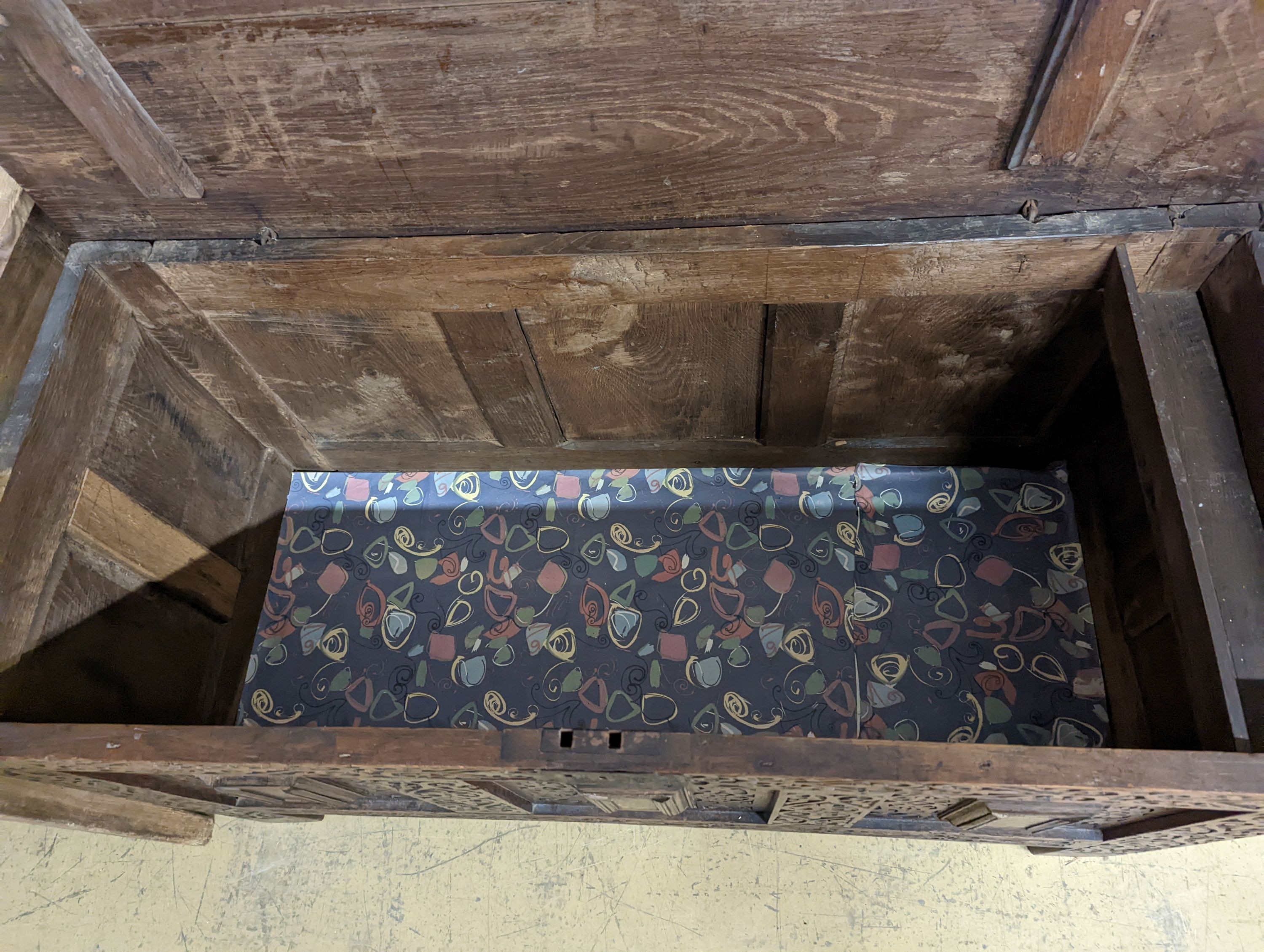 A 17th century carved oak coffer. W-124cm, D-56cm, H-72cm.